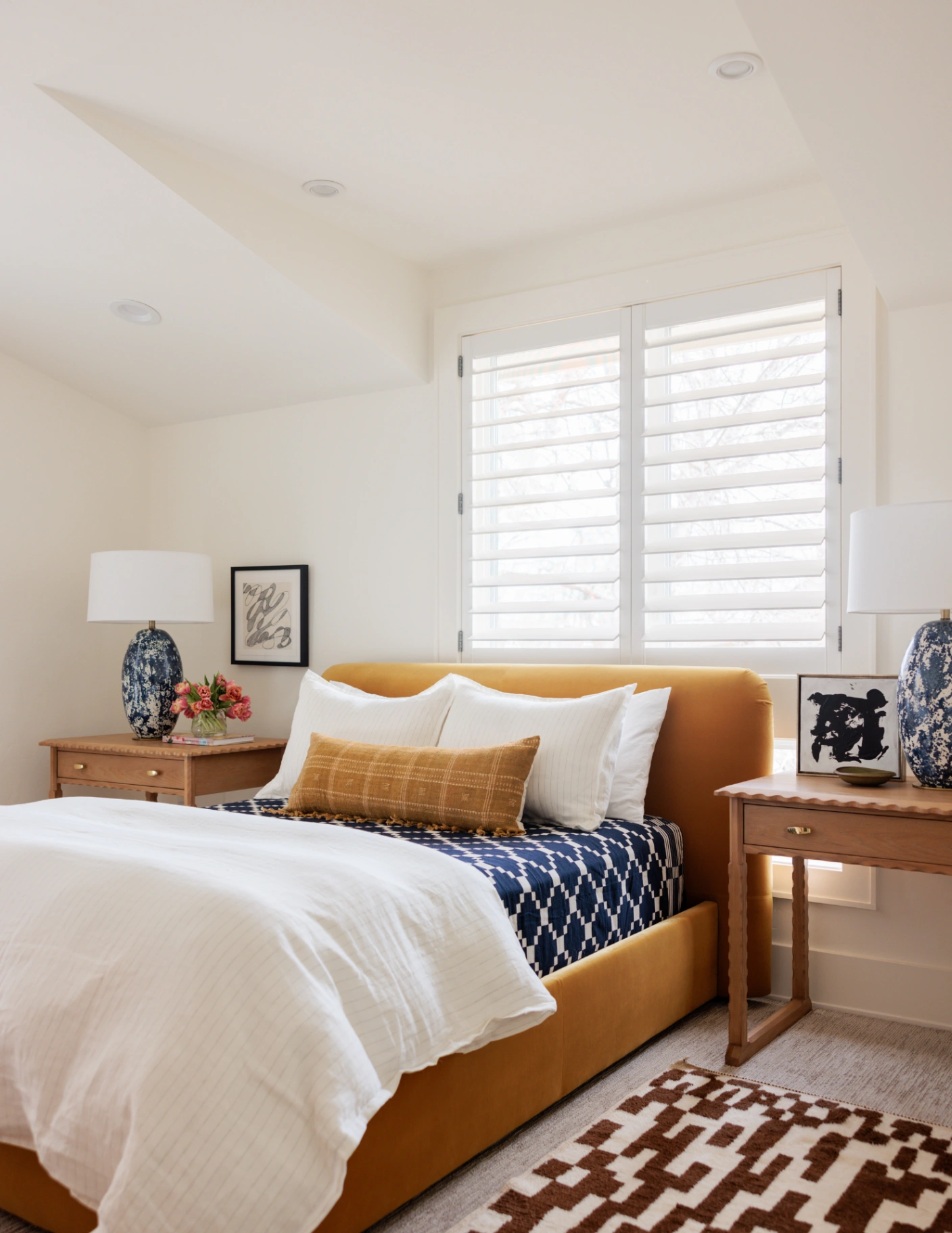 Custom white plantation shutters in a bright and airy bedroom