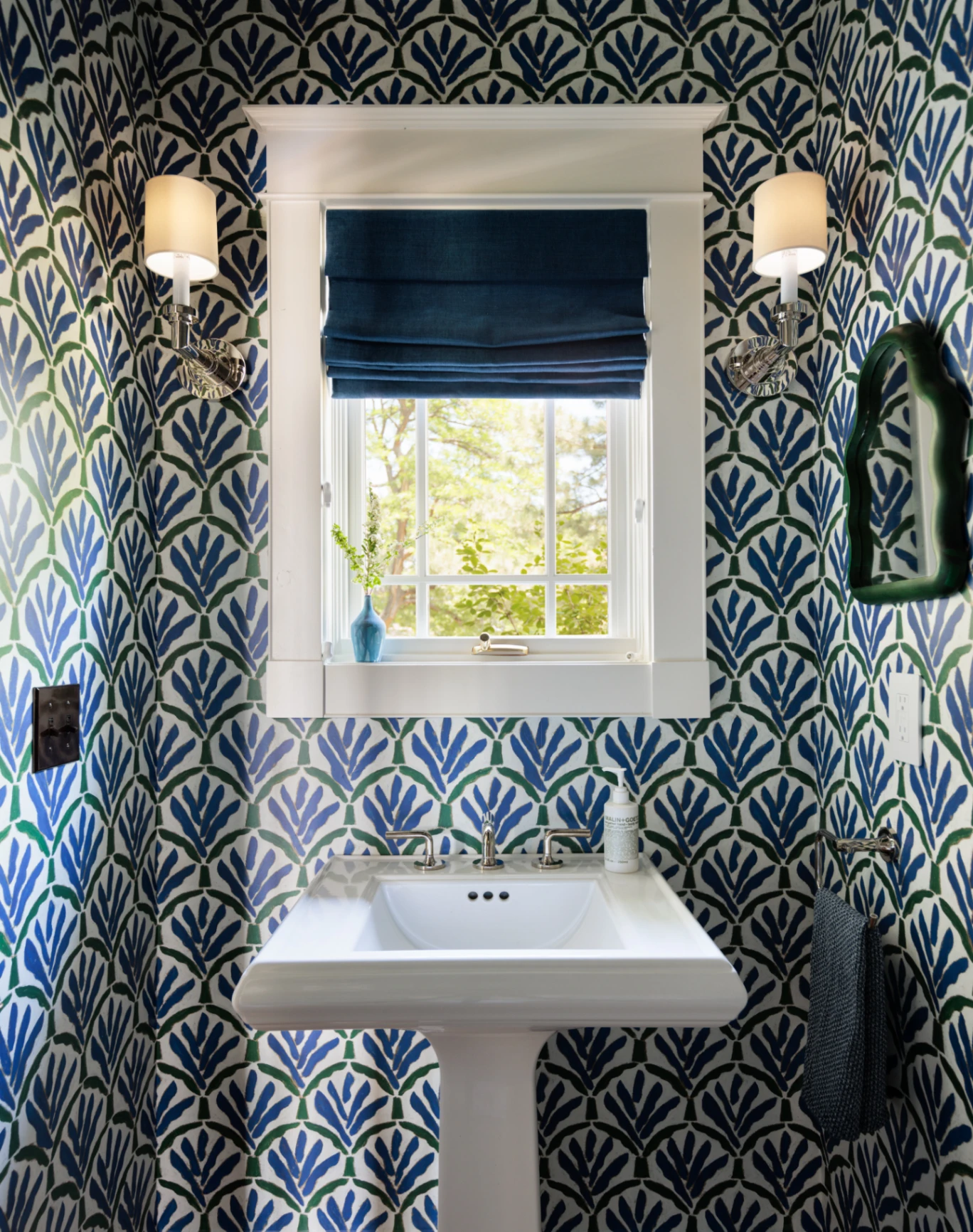 Custom flat Roman shade in deep navy perfectly complementing a vibrant pattern-filled powder room