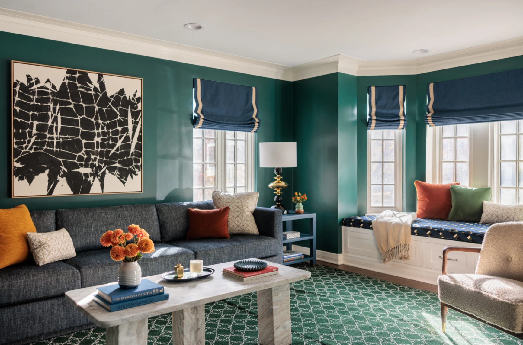 Custom relaxed Roman shades in navy with contrast trim perfectly anchoring a vibrant, color-rich living room