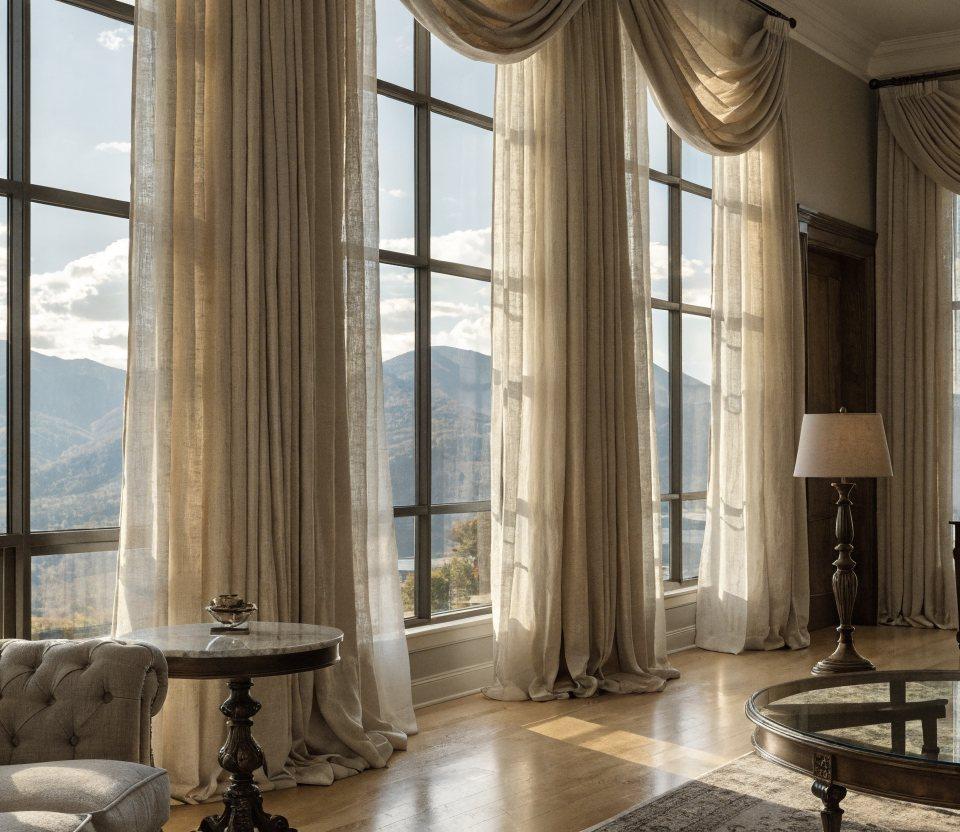 Floor-to-ceiling ivory linen drapery framing tall windows in an elegant Denver living room with mountain views