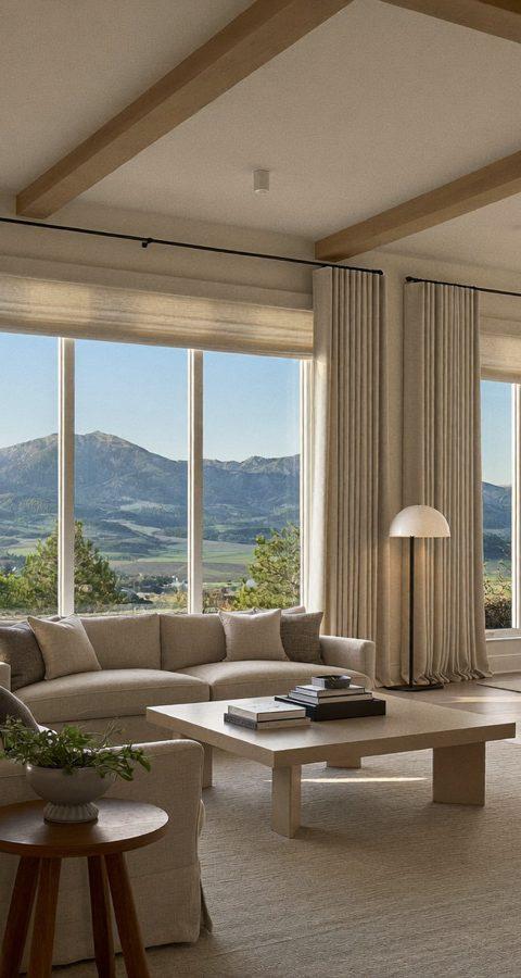 Denver great room with layered linen drapery panels and light-filtering roller shades framing a mountain view