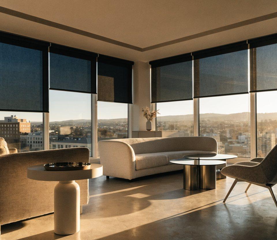 Sleek motorized roller shades at varying heights on a wall of windows in a modern Denver great room