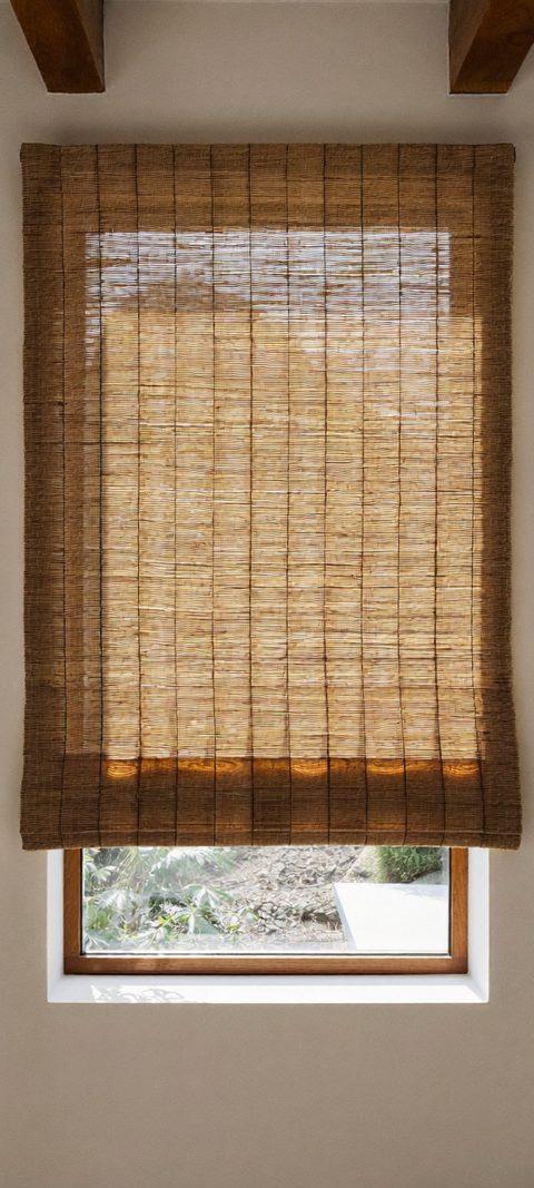 Design studio wall showing roller, cellular, woven wood, and Roman shade styles side by side in neutral tones