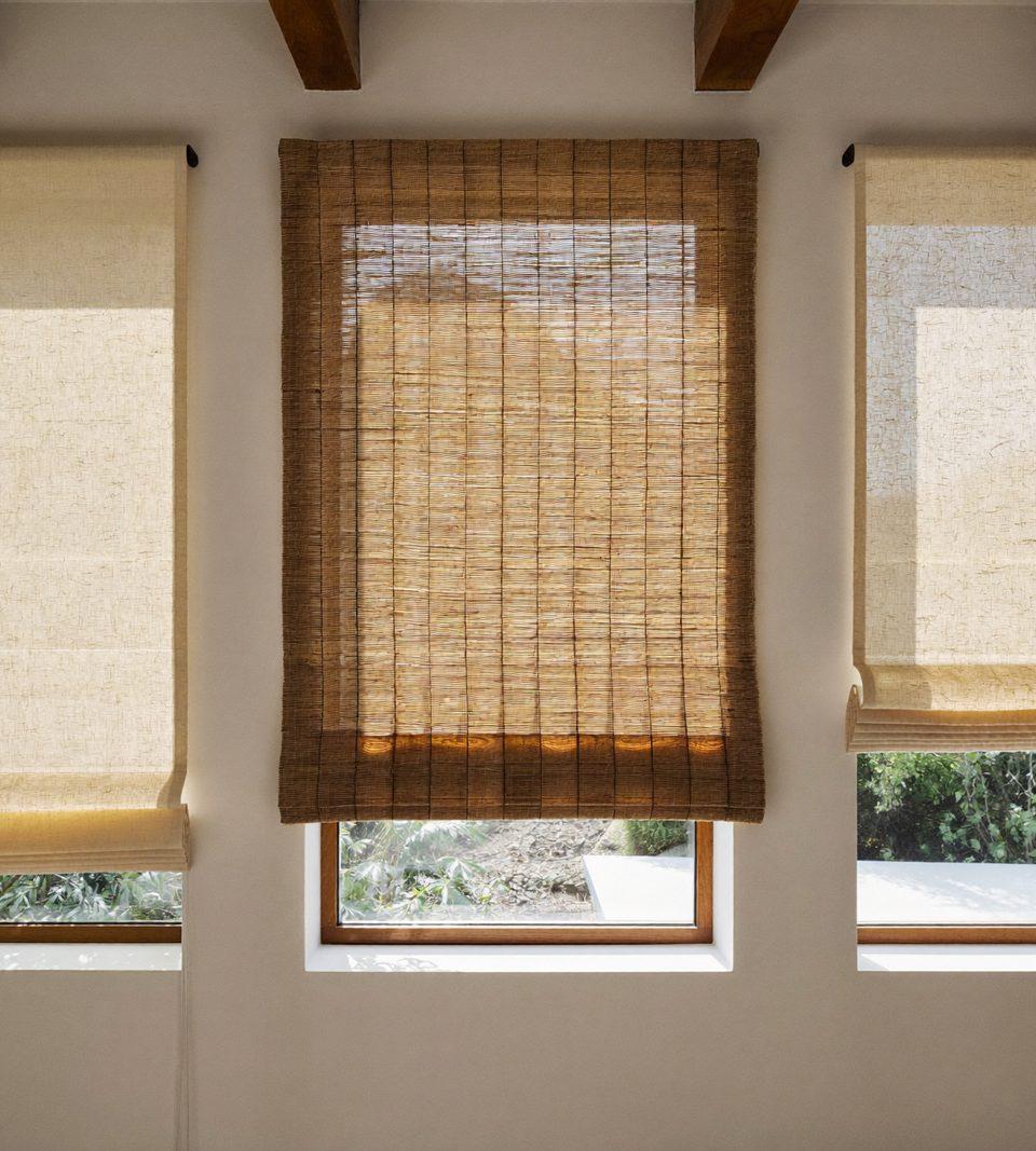 Design studio wall showing roller, cellular, woven wood, and Roman shade styles side by side in neutral tones