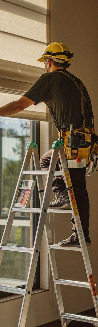 Professional installer mounting a custom cellular shade bracket inside a window frame of a Denver home