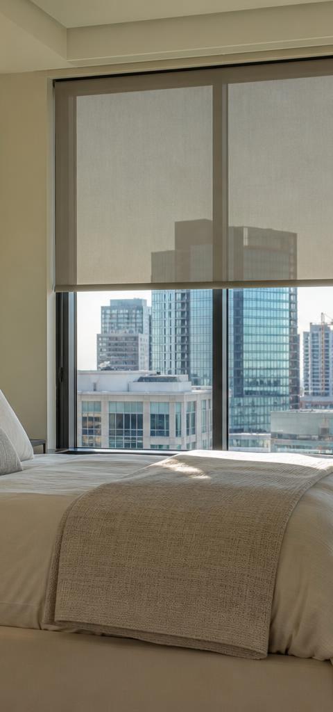 Modern Denver bedroom with motorized roller shades and smart home tablet glowing on nightstand