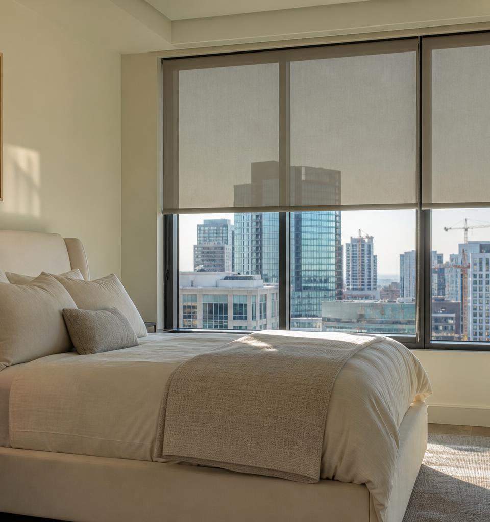 Modern Denver bedroom with motorized roller shades and smart home tablet glowing on nightstand