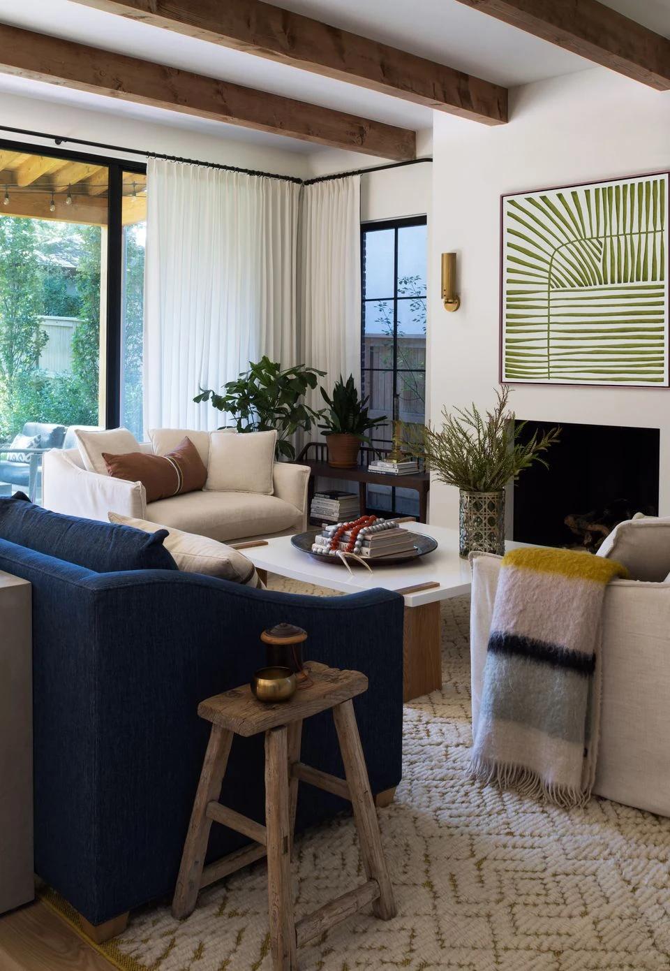Blue upholstered chairs beneath dark drapery in a sunlit living room