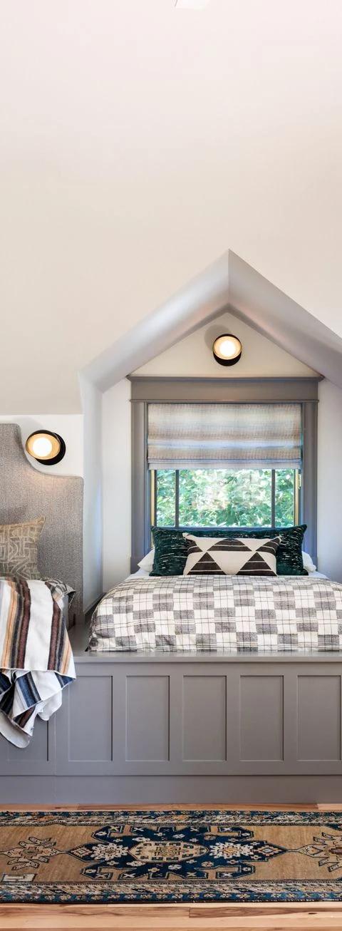 Layered bedroom window treatments surround twin beds in a bright interior