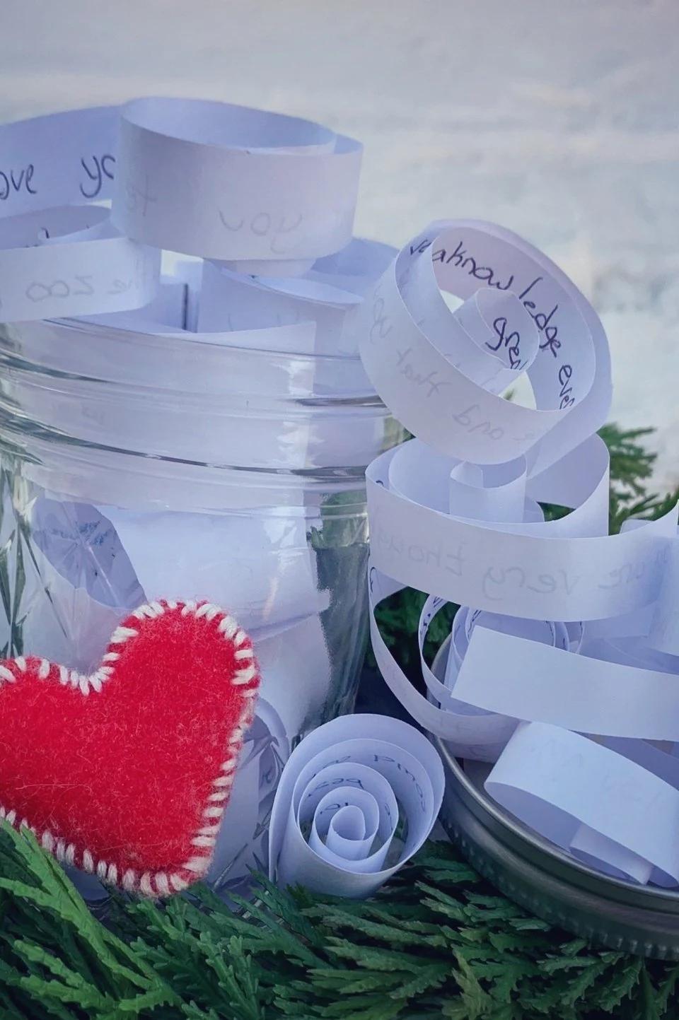Gift wrapped with ribbon and a red heart on a snowy surface
