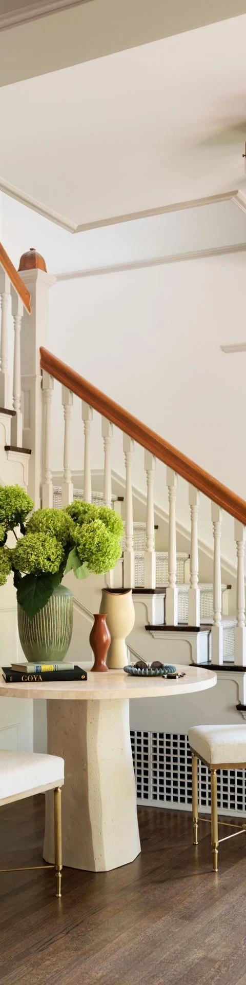Pale window coverings brighten a contemporary living room near a staircase