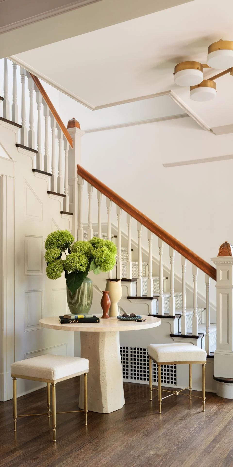 Pale window coverings brighten a contemporary living room near a staircase