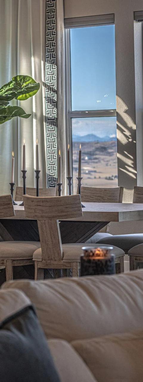 Tall drapery panels frame mountain views above a neutral living room