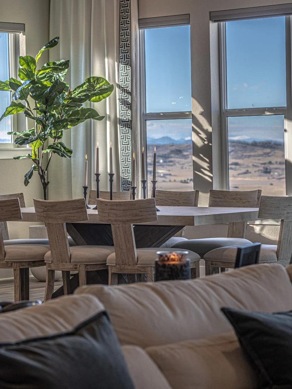 Tall drapery panels frame mountain views above a neutral living room