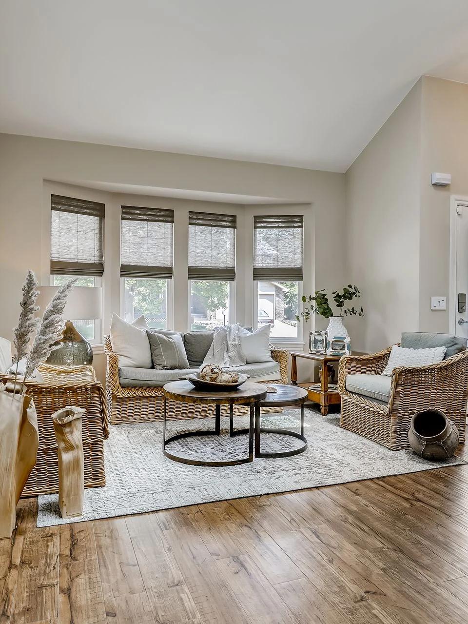 Neutral window shades flank a light filled contemporary living room