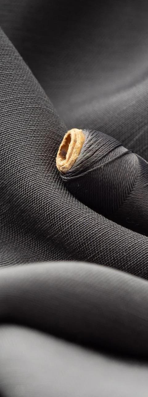 Close view of dark drapery fabric gathered around a decorative hardware finial