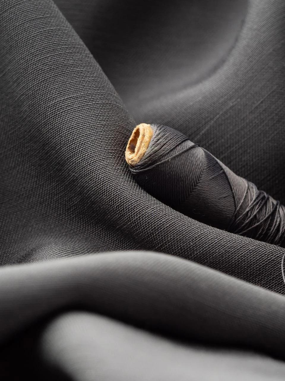 Close view of dark drapery fabric gathered around a decorative hardware finial