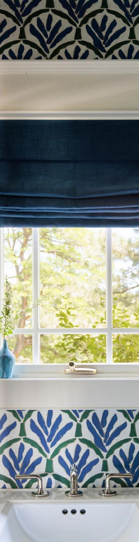 Dark Roman shade inside a small window surrounded by patterned wallpaper