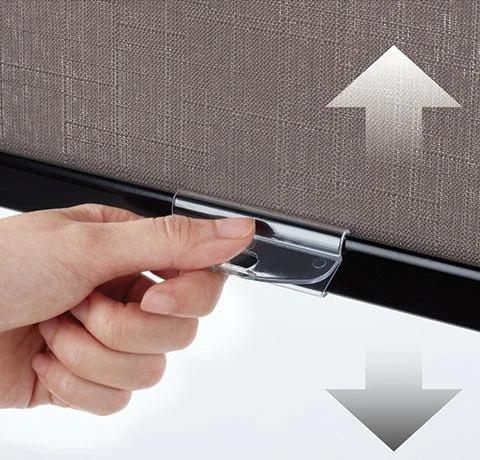 Hand holds a cordless shade handle beneath arrows showing vertical movement