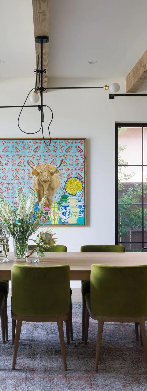 Light drapery frames tall living room windows with a distant view