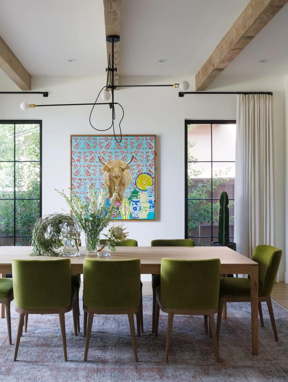 Light drapery frames tall living room windows with a distant view