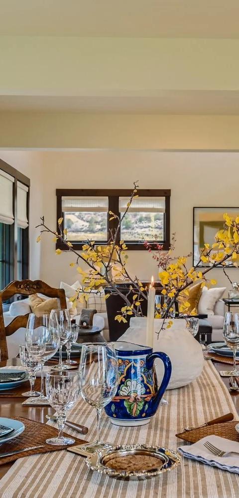 Patterned upholstered chairs and tall windows fill a bright living room
