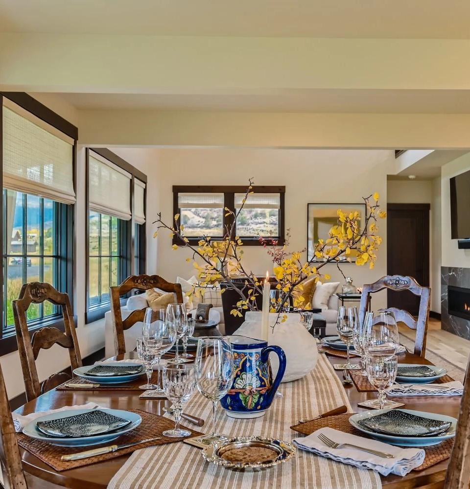 Patterned upholstered chairs and tall windows fill a bright living room